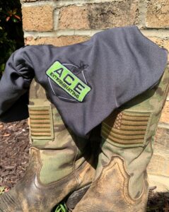 An Ace Exterminating shirt on top of military boots